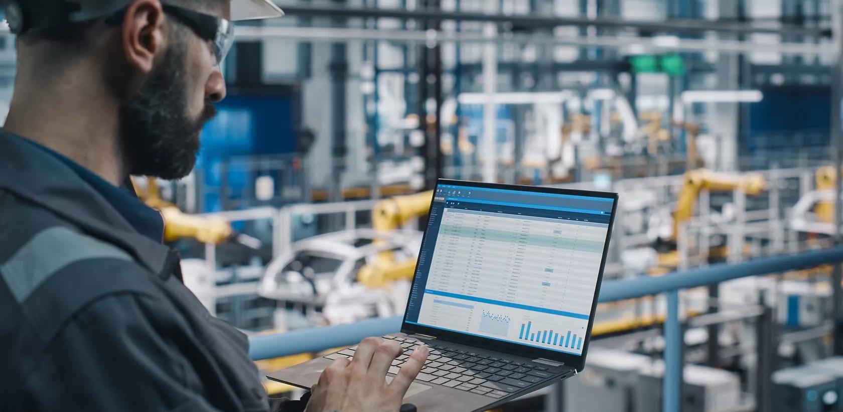 Man using laptop inside a factory