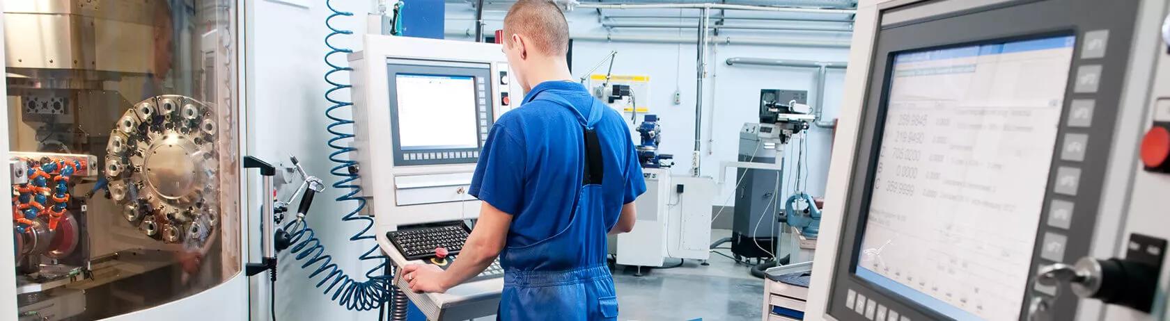 Technical operative using controls on an industrial cutting machine