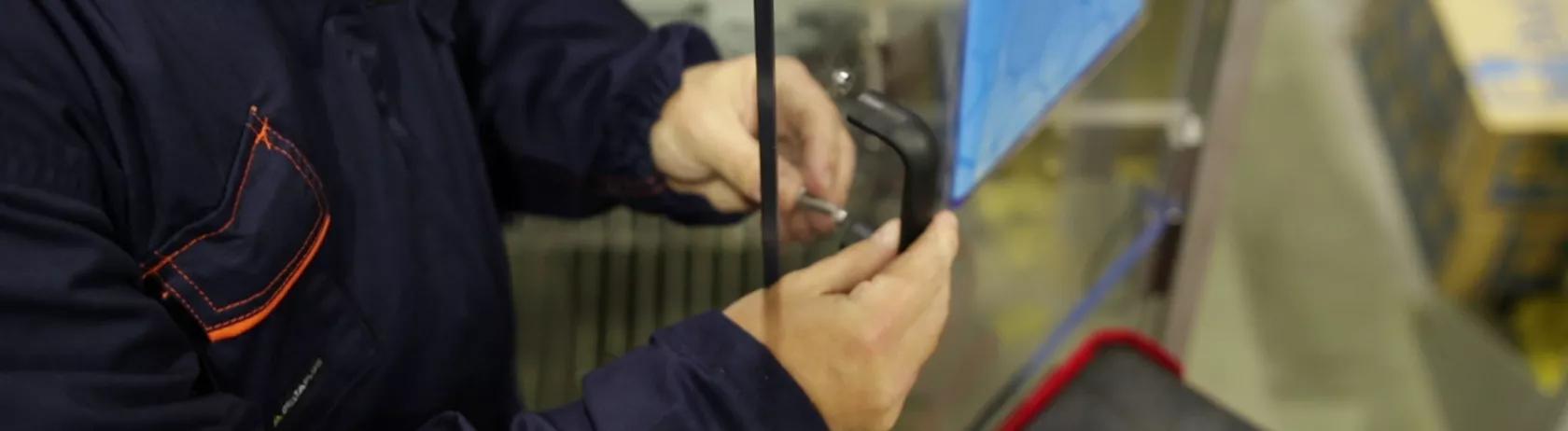 Worker installing a pull handle on an industrial machine 