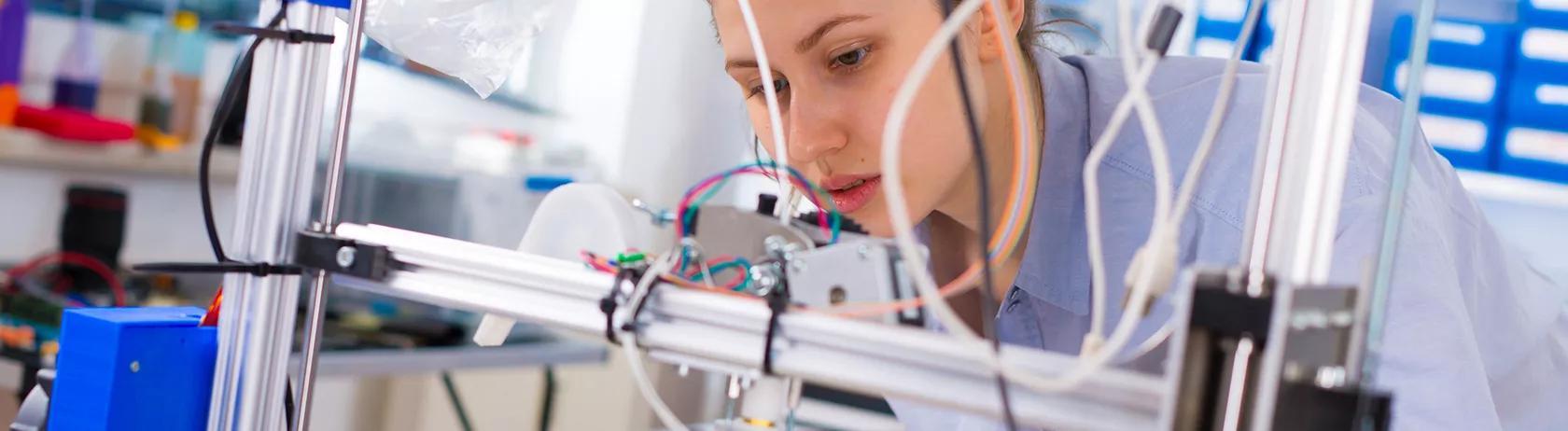 Woman prototyping on a 3D printer