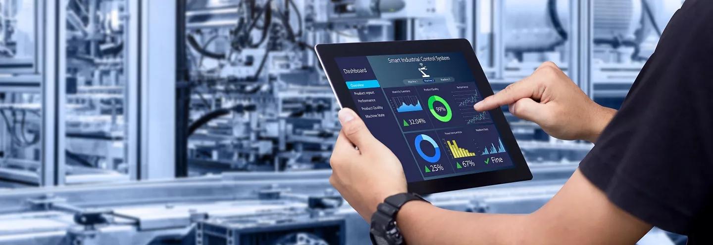 Man looking at smart manufacturing dashboard on tablet