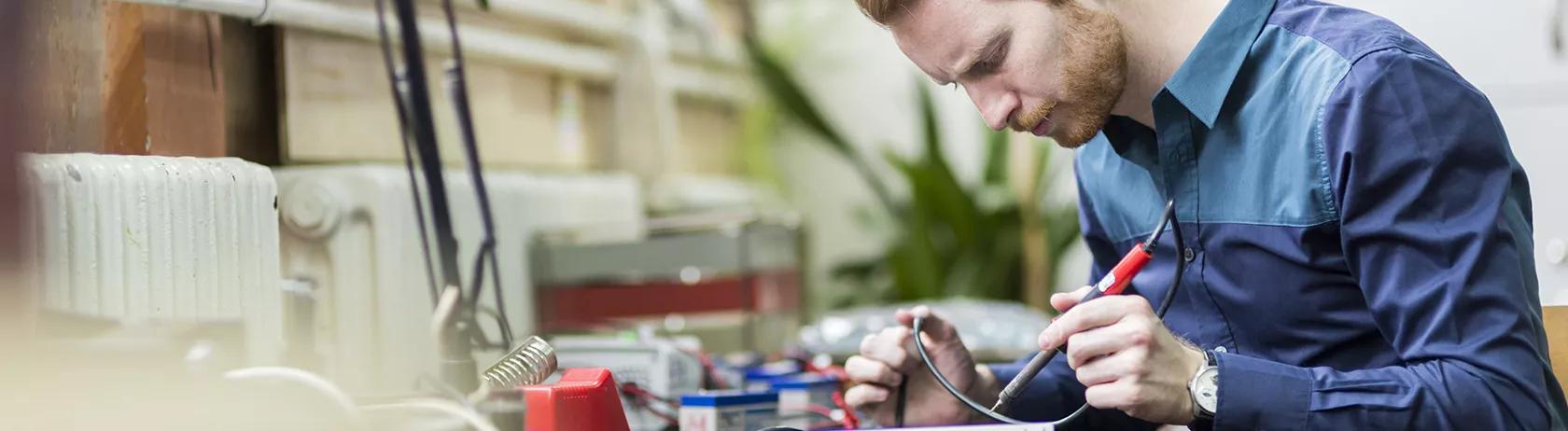 Elektroingenieur, der an einer Leiterplatte arbeitet