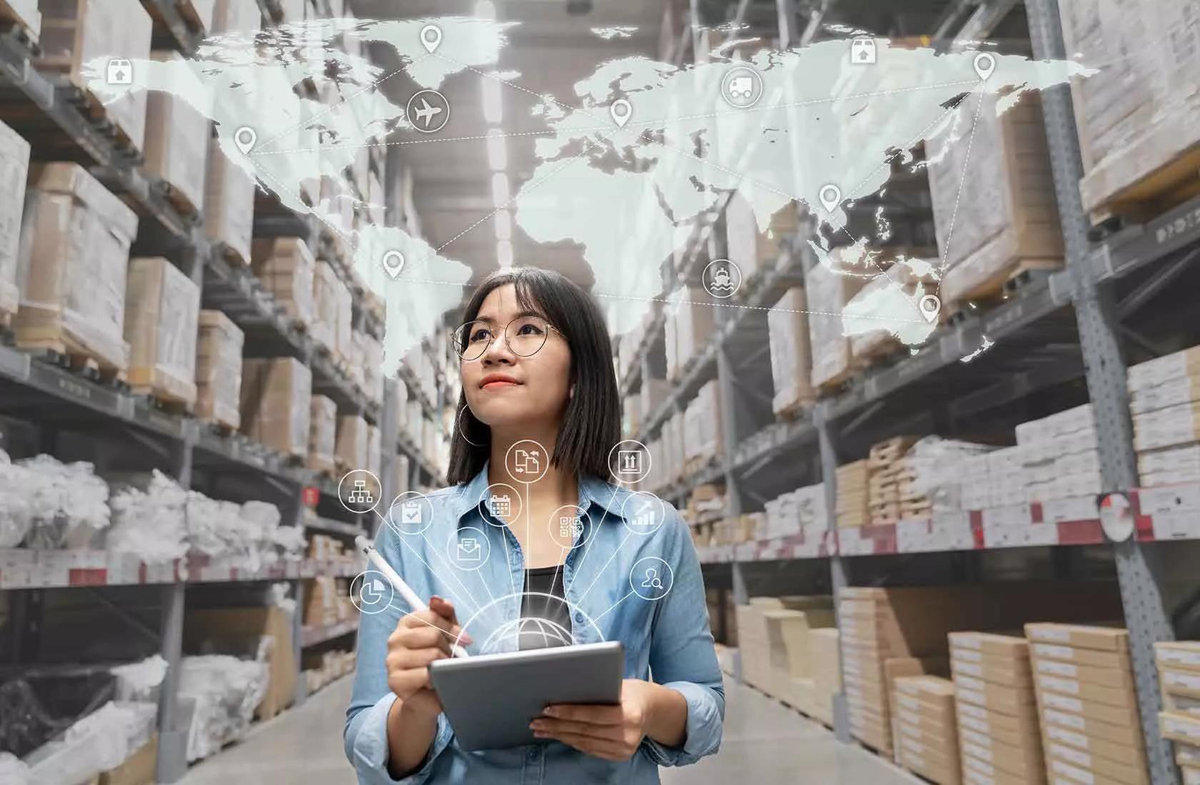 Frau mit Tablet geht durch Industrie 4.0-Lager