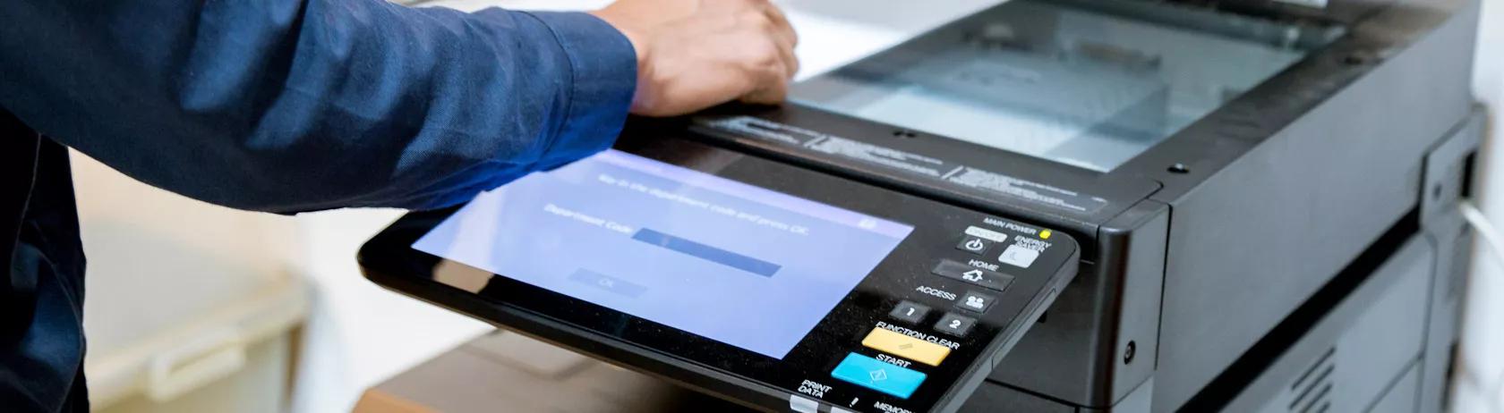 Man using an office printer with digital display