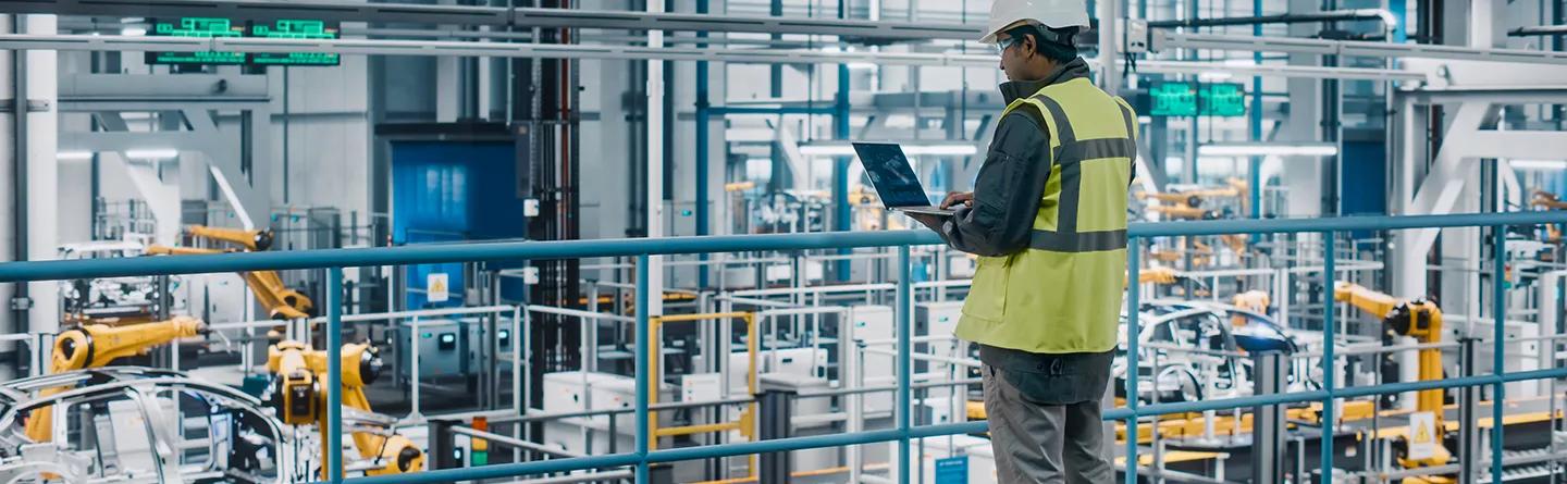 A man with a device oversees a production line