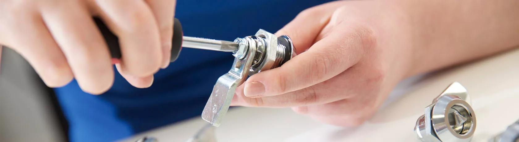 Worker tightening a compression latch ready for installation on an application