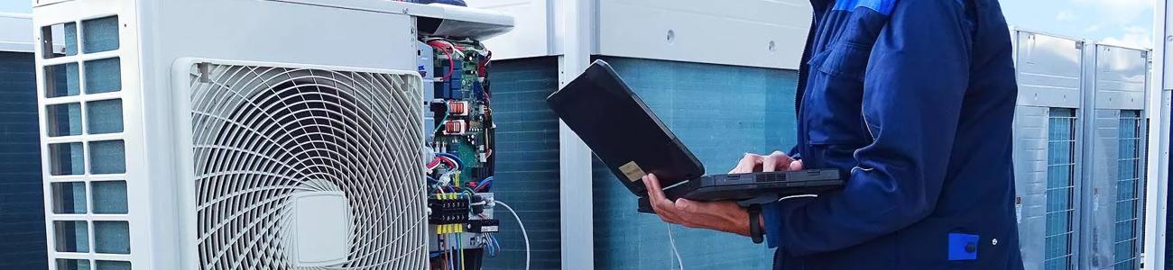 Person with laptop looking at air con wiring