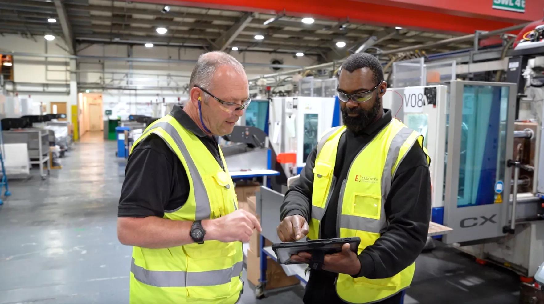 Two colleagues using a digital tablet in Essentra’s plastic components factory in Kidlington, UK