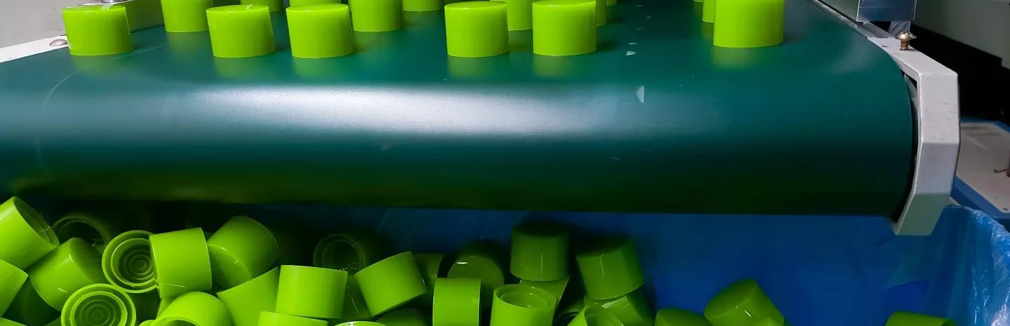 green injection-moulded plastic components in a factory 