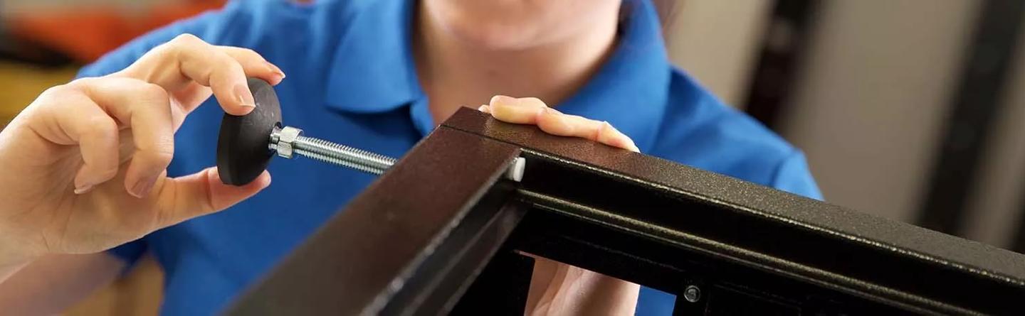 Lady fitting levelling feet to a server cabinet