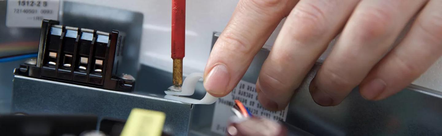 Man screwing a cable clamp onto a consumer appliance