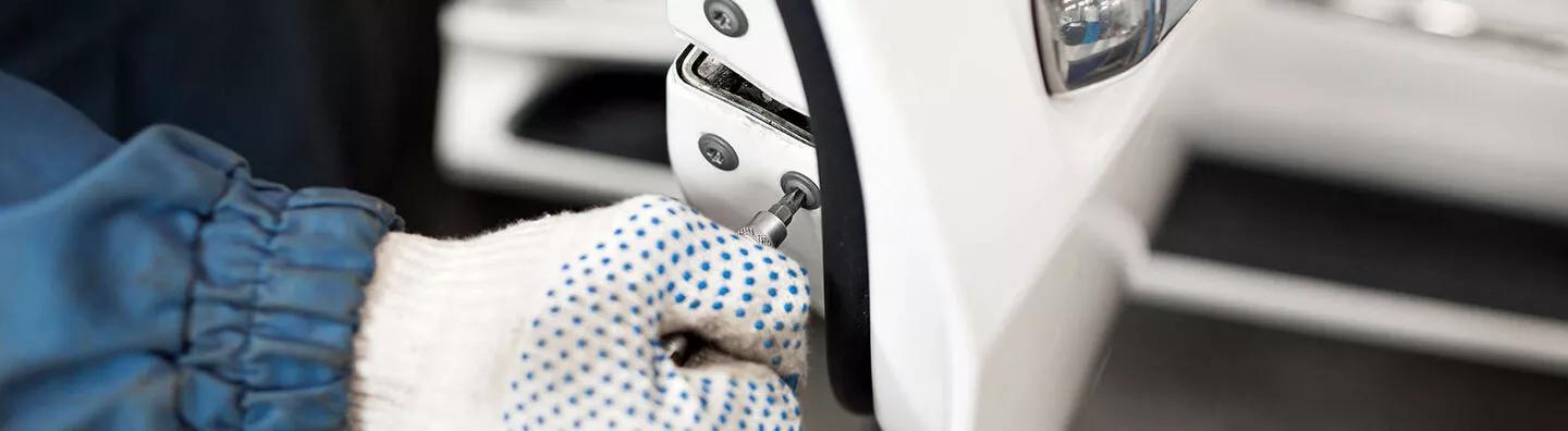 Man working on a rotary latch on a car door