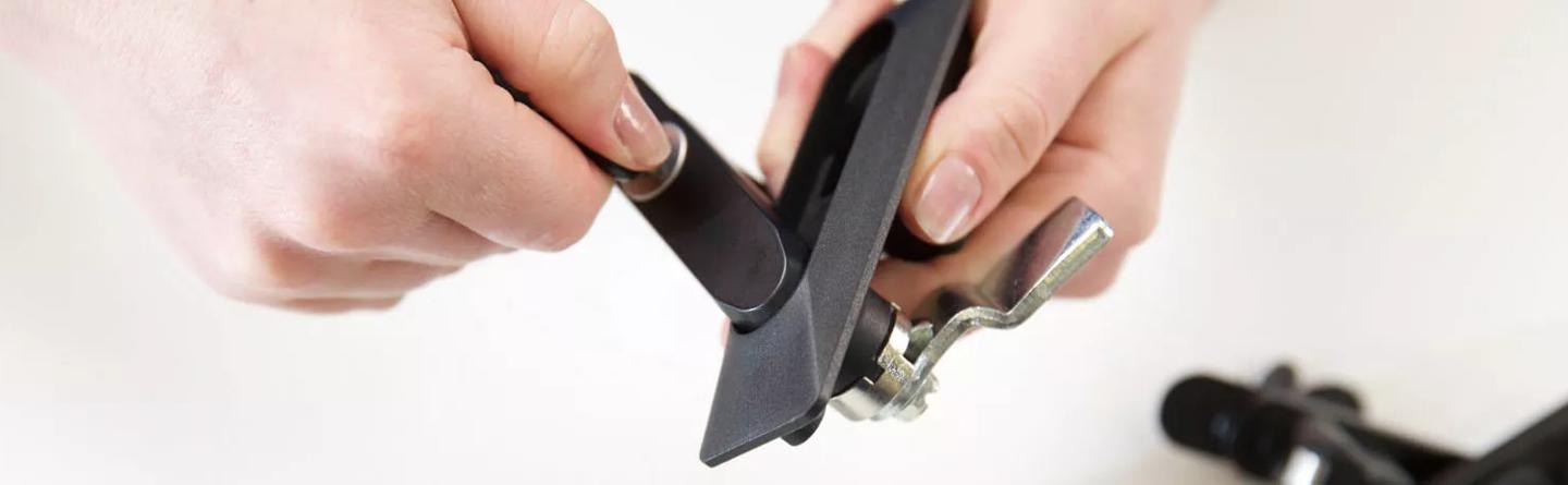 Someone inspecting cam lock latches on a table