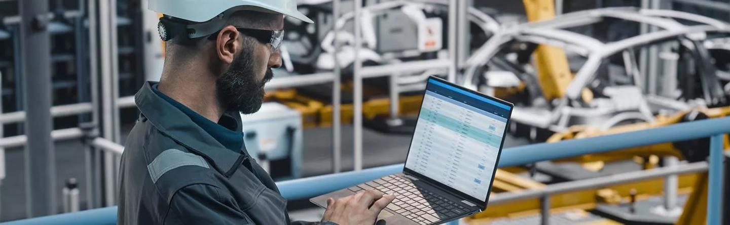 Image of man wearing hard hat and holding laptop